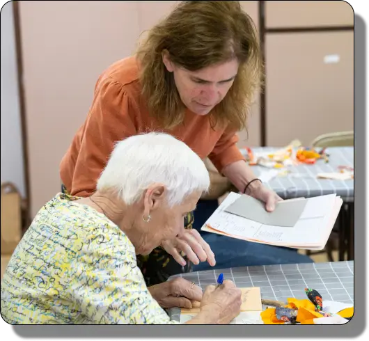 LBA client writing a card with help from LBA staff member