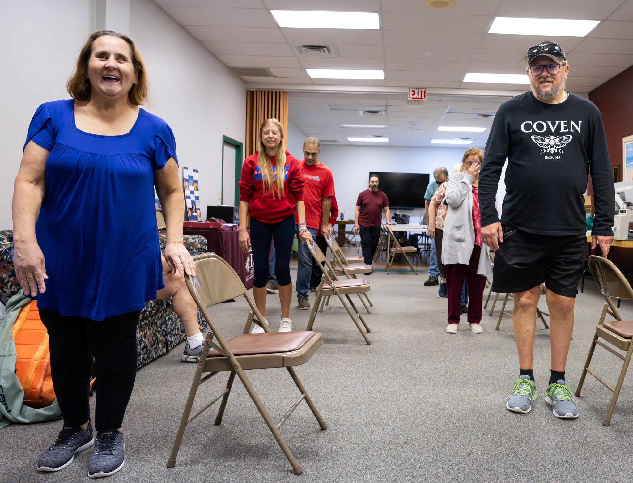 LBA clients standing around chairs, ready to begin an activity