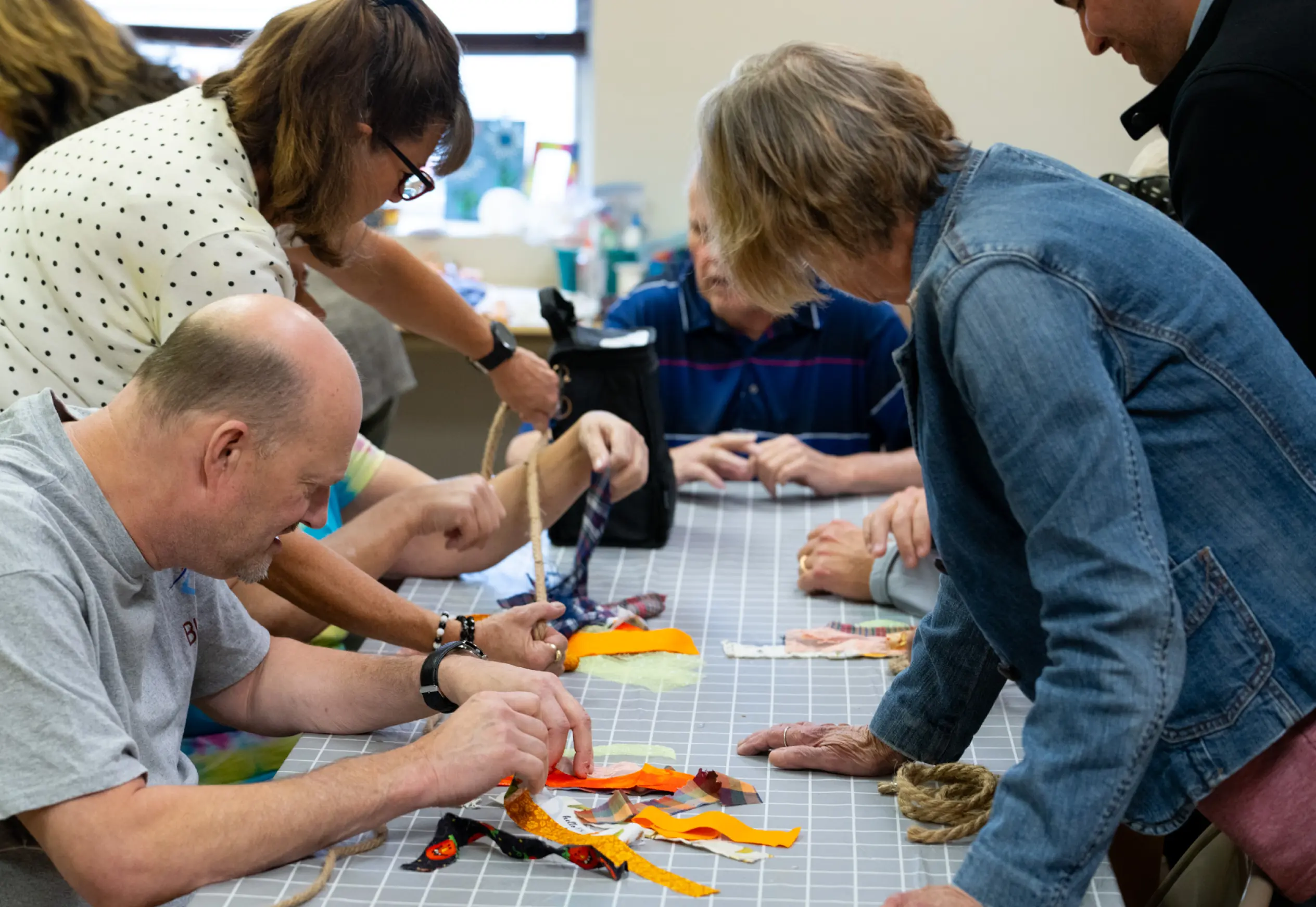 LBA Clients and staff around a table creating a craft together