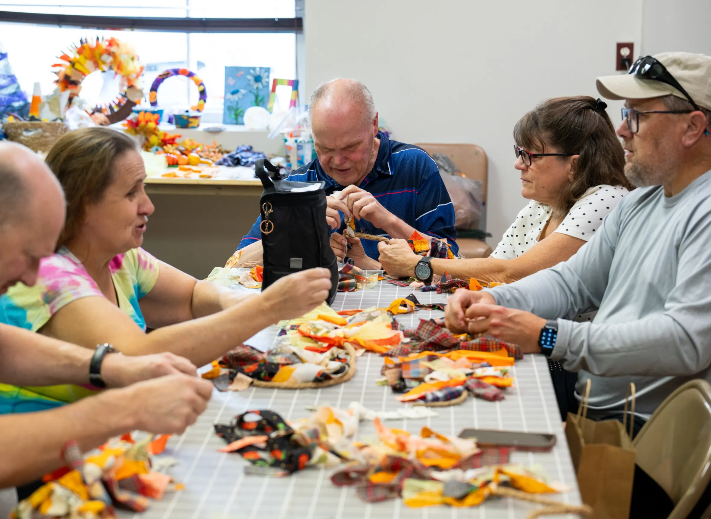 LBA clients sitting around a table, talking and maing crafts